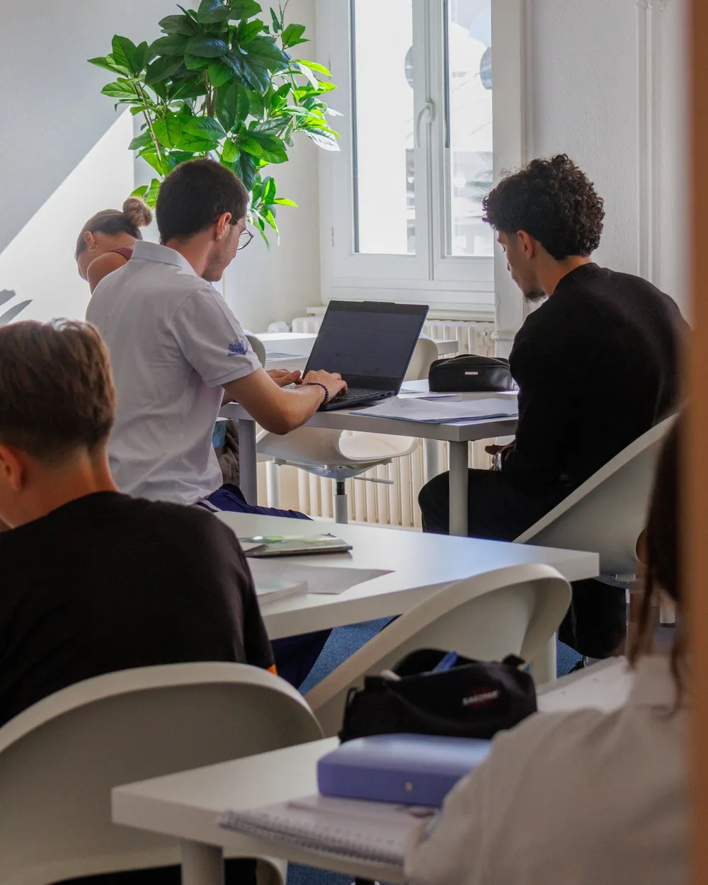 Gymnase students working on laptops in a room at the SOS centre